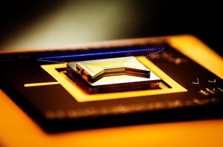 Квантовый чип от IonQ с наложенным изображением ионов